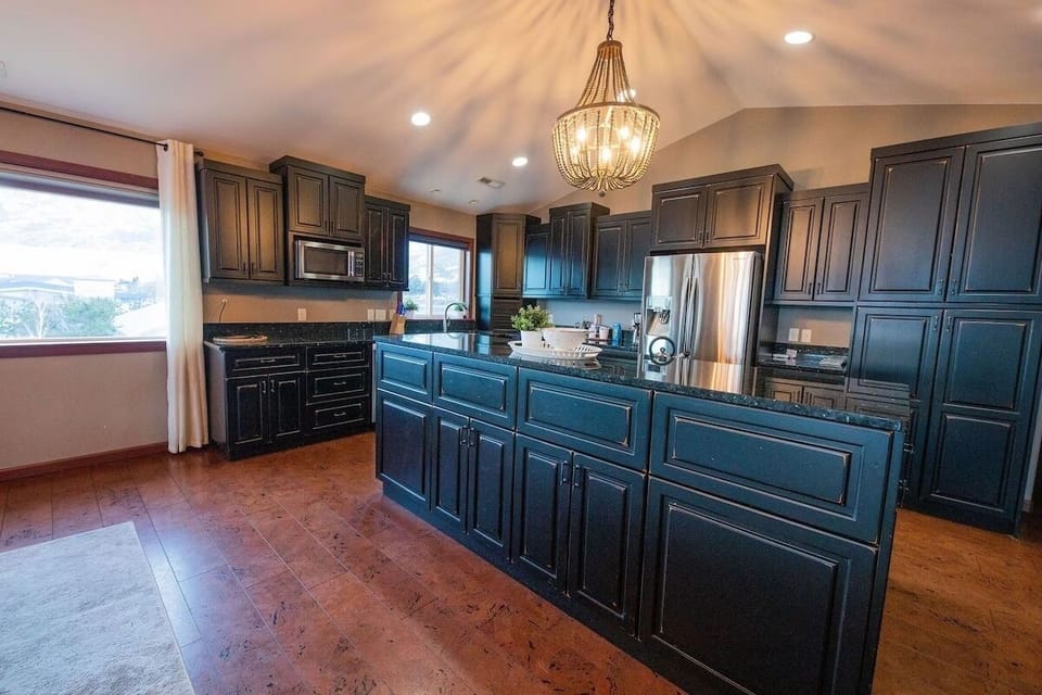 Granite countertops, custom cabinets, modern induction stovetop with downdraft.