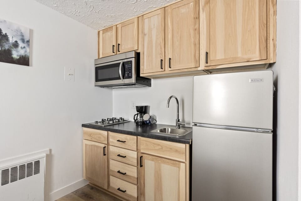 Efficient kitchen area offering stainless appliances and wood-style cabinetry.