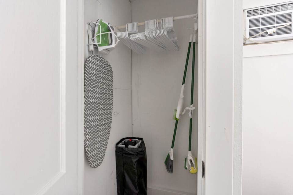 Functional storage space offering an ironing board for guest use.