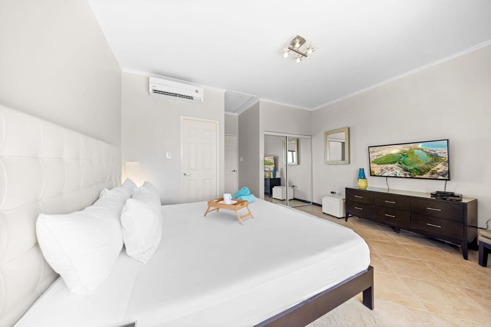 A wall-mounted TV offers convenient entertainment in this cozy space.