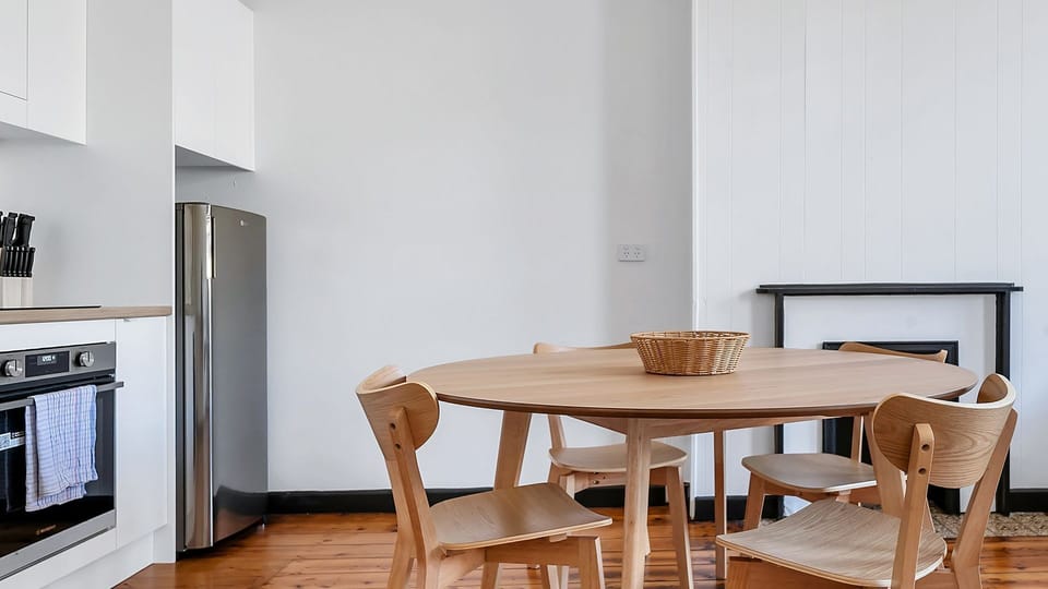 Chic dining area with a natural wood finish, perfect for intimate meals.
