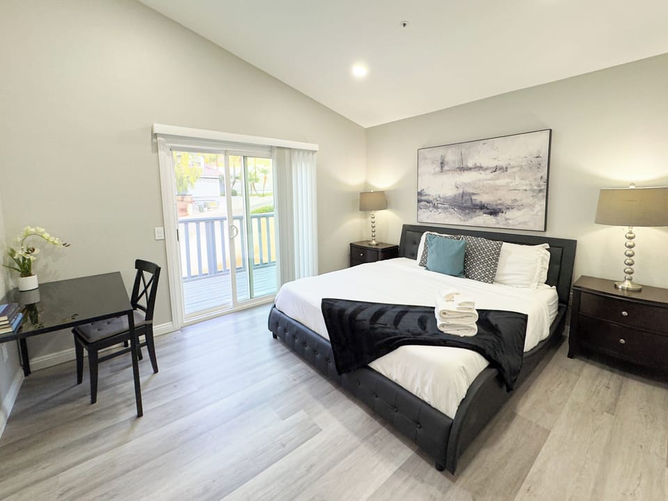 A luxurious haven with a king bed, private balcony, office desk & elegant decor.