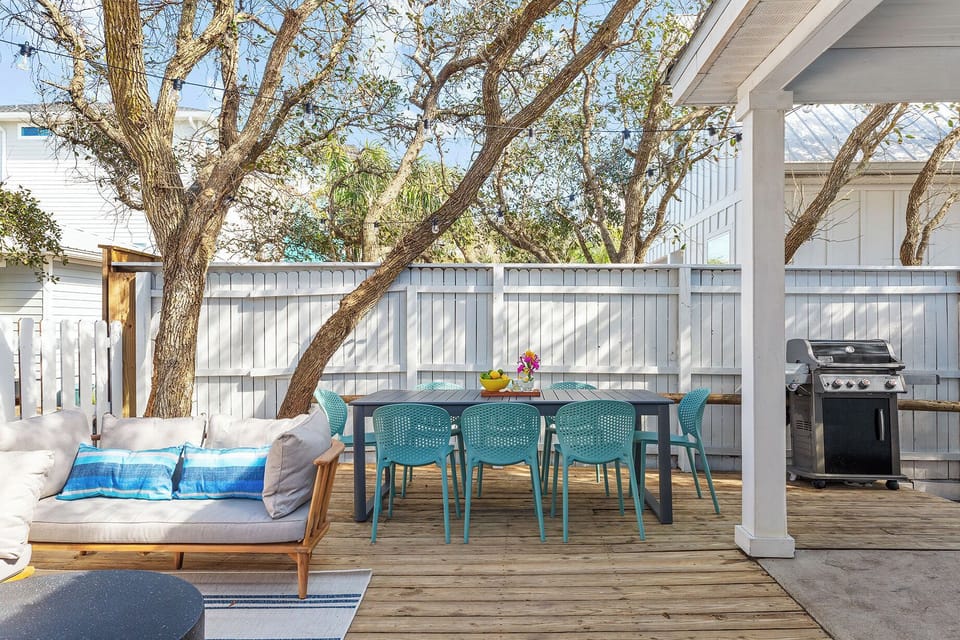 Backyard features a grill, utensils and dining table.