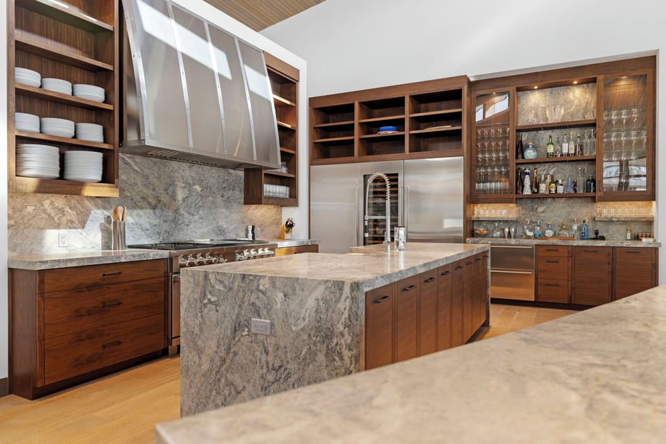 The kitchen with a large island and stainless-steel refrigerator.