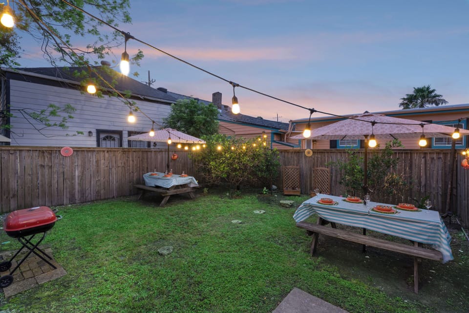 Enjoy a meal or drink in your NOLA backyard oasis with a charcoal grill, picnic benches, umbrellas, 