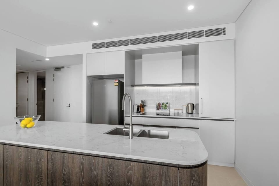 Fully equipped modern kitchen with premium appliances, stone benchtops and ample storage for your convenience.