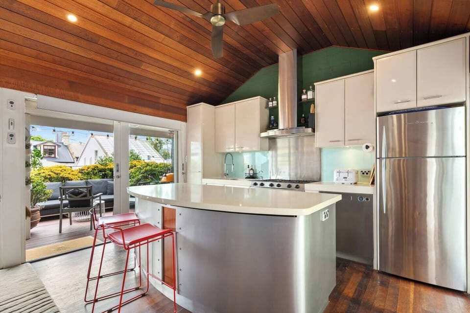 A modern kitchen with dining area, complete with warm timber accents and seamless access to the outdoor deck.