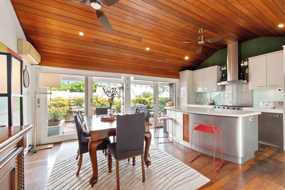 Cook and dine in style in this modern kitchen and dining area, featuring high-quality appliances and seamless access to the deck for alfresco meals.