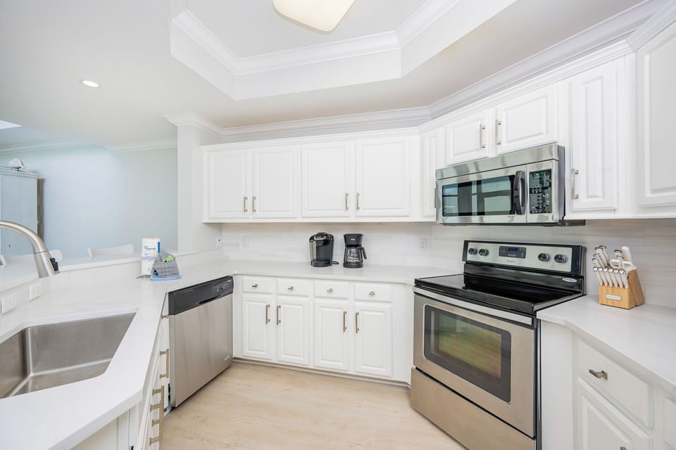 This kitchen features white cabinetry, stainless appliances, a Keurig and a coffee maker for a delightful cooking experience