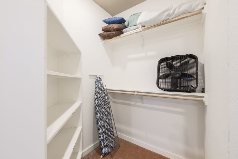 Room with clothes rack, iron, and ironing board 👔  Keeps clothes fresh and organized during your stay ✨