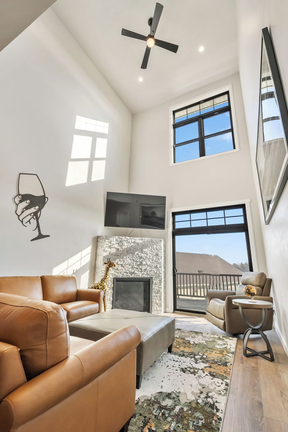 Vaulted, bright living room with gas fireplace, Smart TV and access to a deck