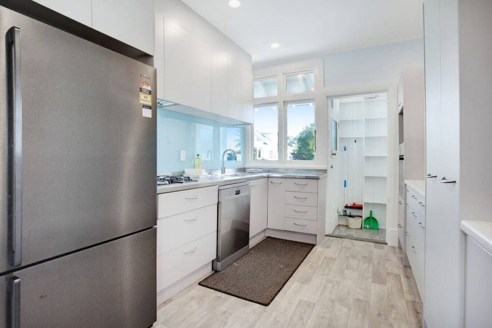 The kitchen has a dishwasher, fridge/freezer, microwave, cooktop, and oven.