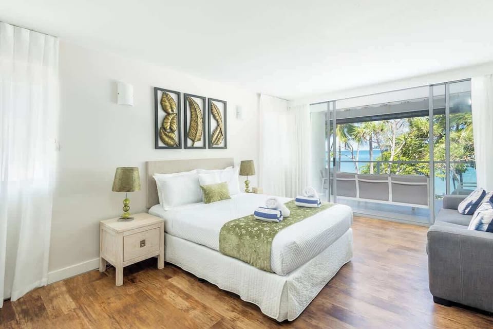 Wake to views across the Esplanade in the primary bedroom, where a king bed, soft natural light, and direct access to the ensuite create a calm coastal retreat.