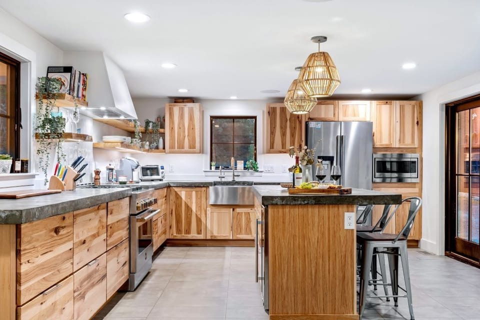 Kitchen with appliances, custom hickory cabinetry, and concrete countertops.