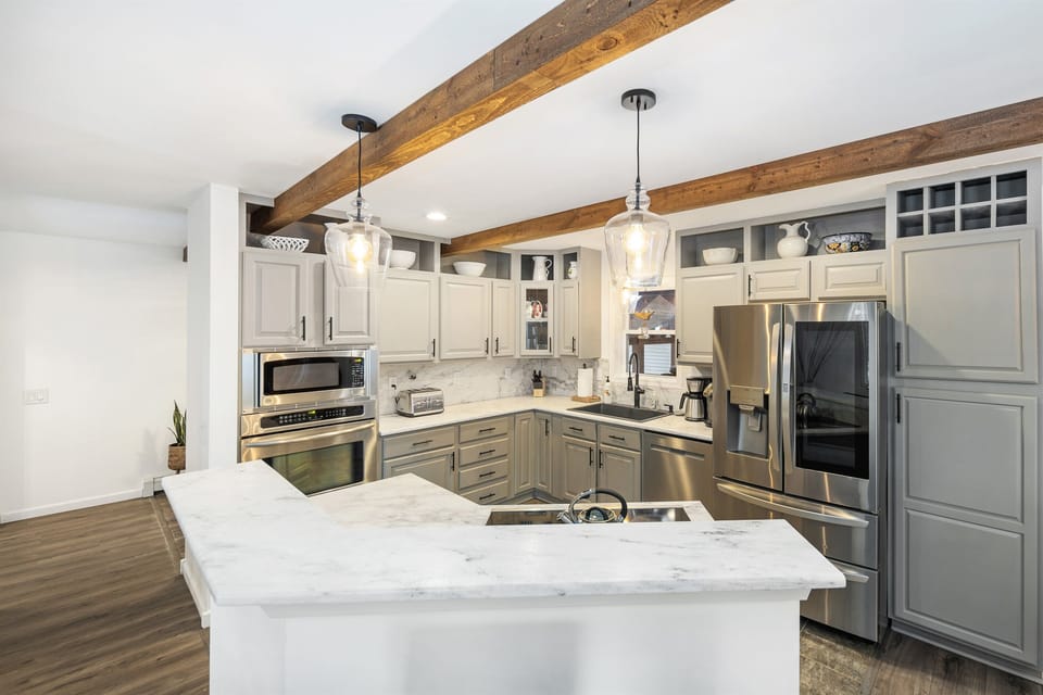 The kitchen features stainless appliances, granite countertops, and on-trend lighting