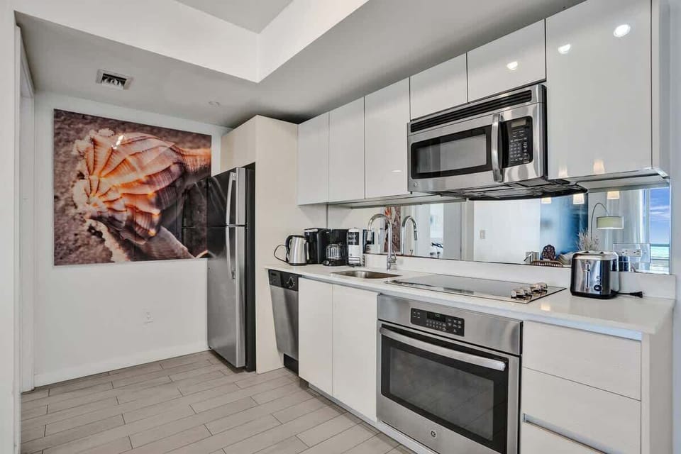 Fully equipped kitchen with stainless steel appliances and dinnerware