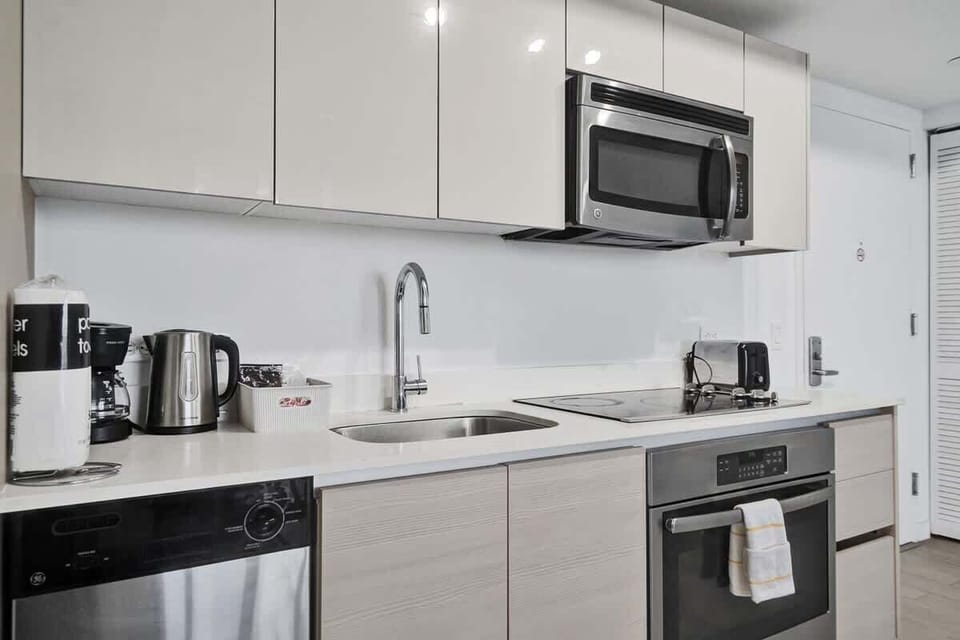 Fully equipped kitchen with stainless steel appliances and dinnerware