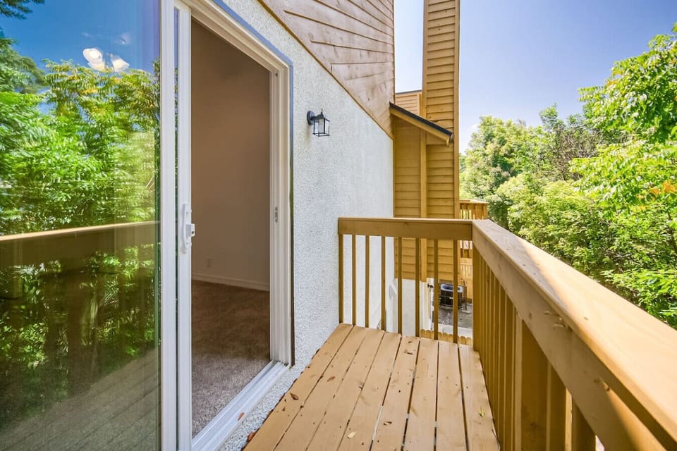 Cozy balcony overlooking greenery and fresh air.