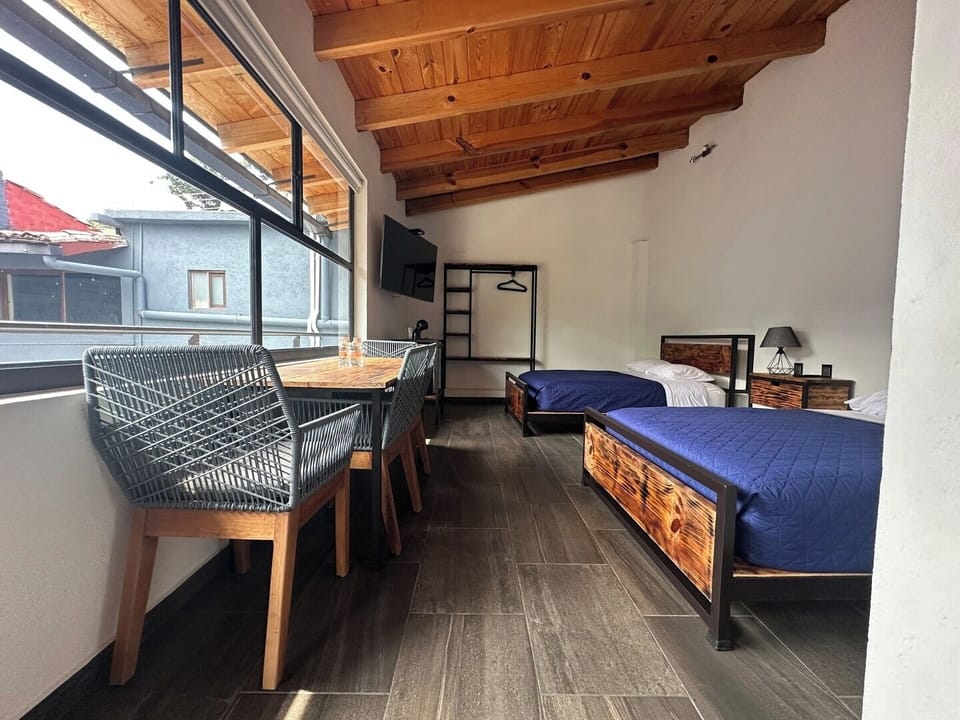 Bienvenido a tu refugio ideal: una habitación cuádruple con dos camas matrimoniales, TV y conexión a internet. Relájate en el espacio que cuenta con mesa y sillas, perfecto para compartir momentos especiales.