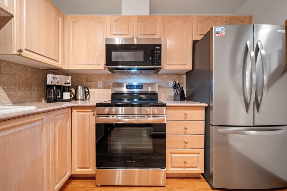 The kitchen includes a range, microwave, fridge/freezer and dishwasher.