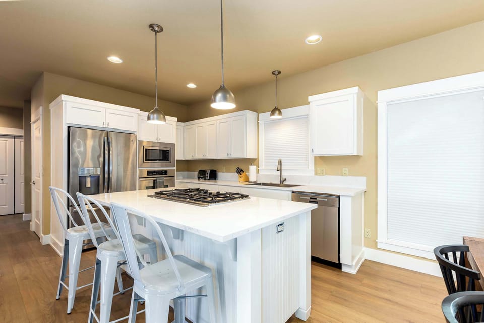 The kitchen also features a large refrigerator, and other stainless-steel appliances.