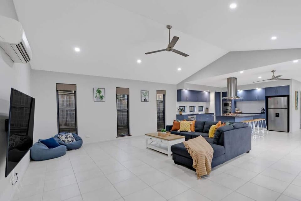 The expansive open-plan living space is perfect for entertaining, with seamless transitions from the lounge to the kitchen and dining area.