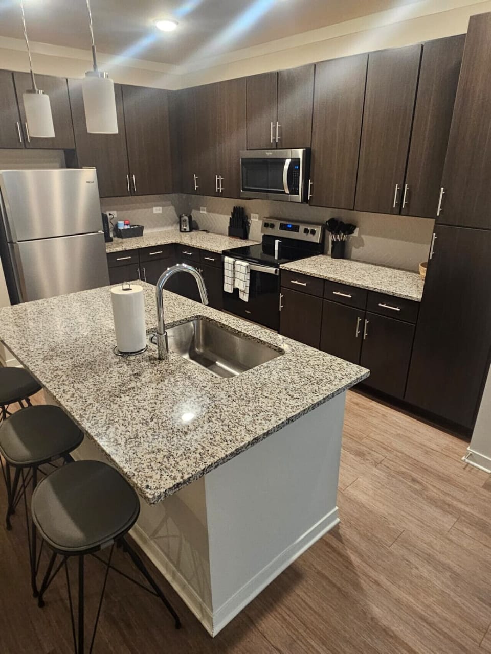 Stylish kitchen featuring premium finishes, spacious granite countertops, and full-size stainless steel appliances — ideal for extended stays.