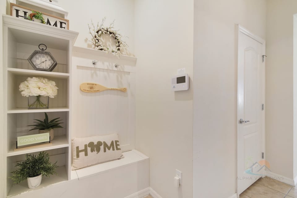 Welcoming entryway with cozy decor and a built-in shelving unit.