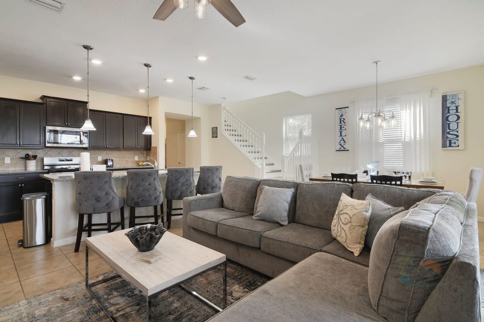 Spacious open-plan living area with large couch and modern kitchen.