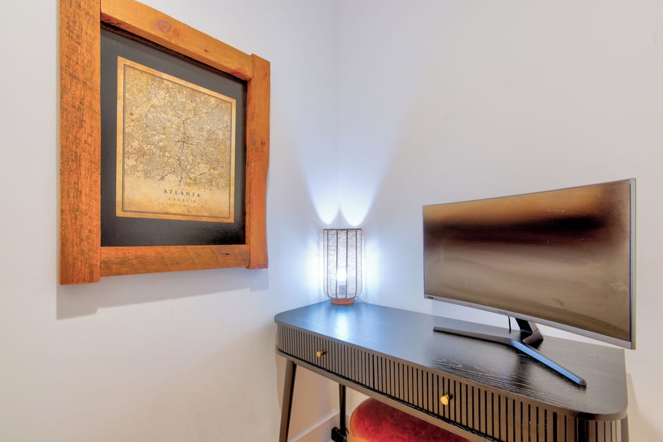 Framed Atlanta map and a curved smart TV bring local character to the lounge.