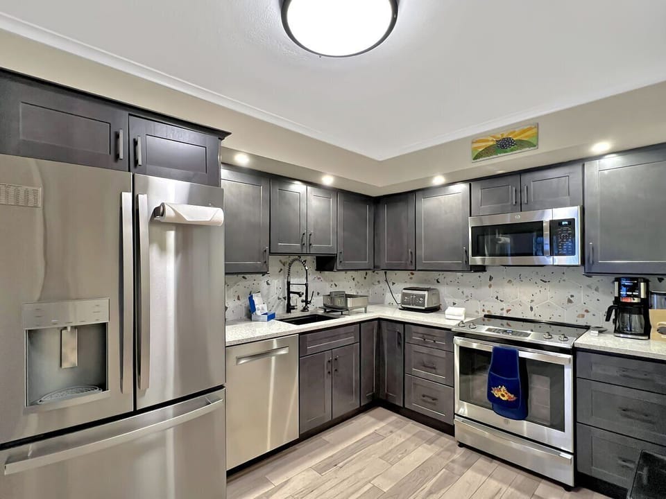 Refrigerator with ice machine, dishwasher, electric stove with oven, microwave.