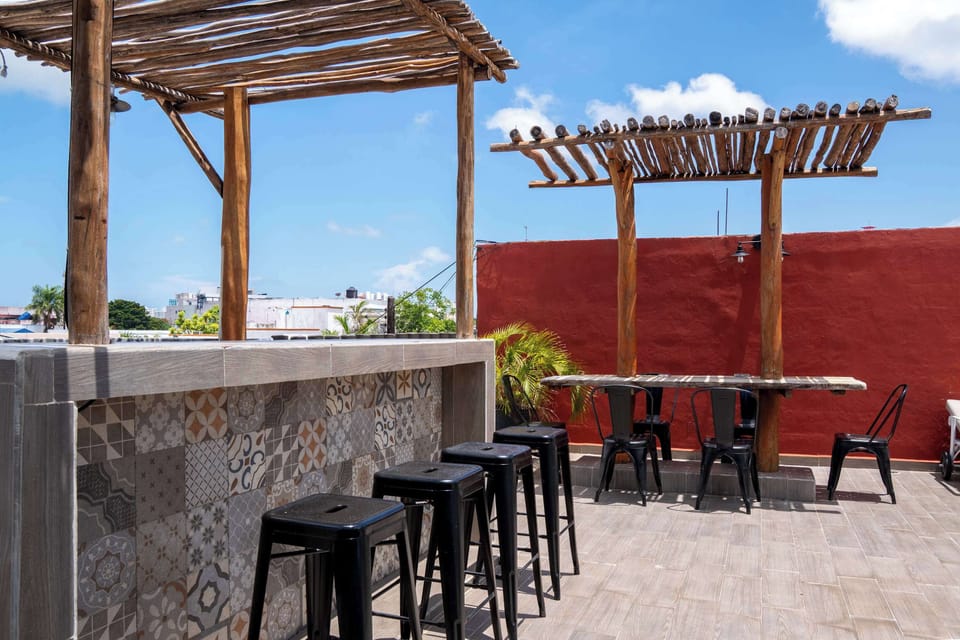 Shaded rooftop bar with stylish tile and stools, kick back with a drink and open-air city views