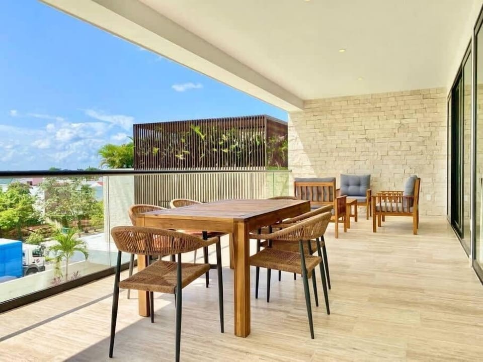 Terraza con comedor con vista a la alberca.