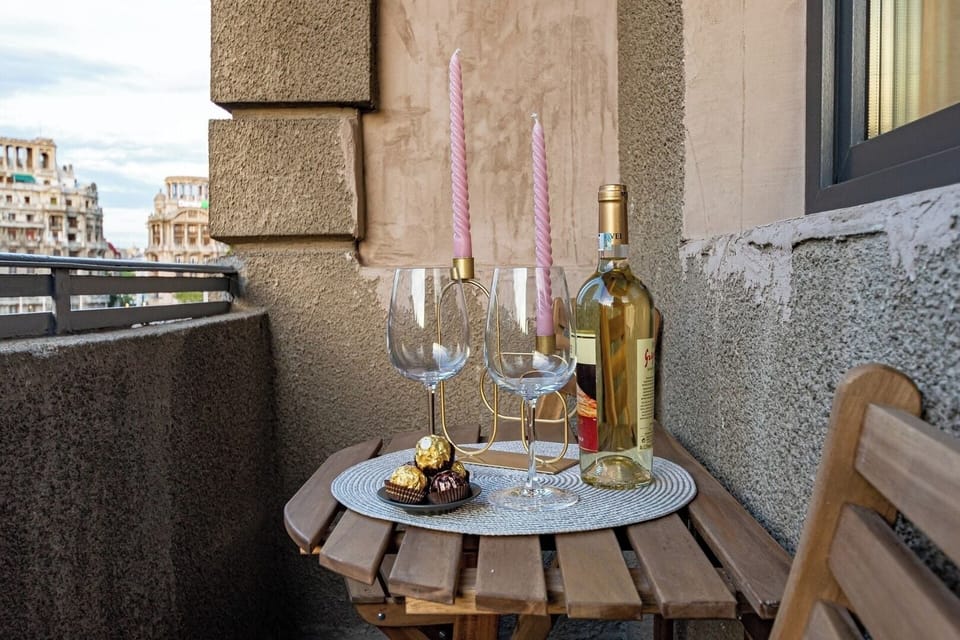 Small table and chair on the balcony that has a city view