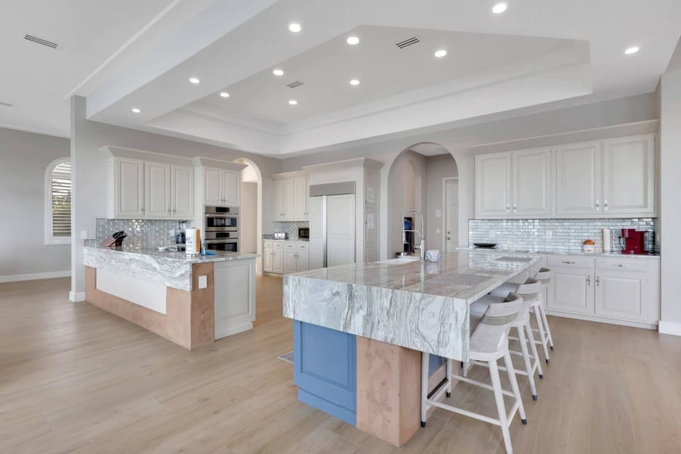 The chef's kitchen features a Sub-Zero refrigerator/freezer, double ovens, smooth cooktop, farmhouse sink and dishwasher.