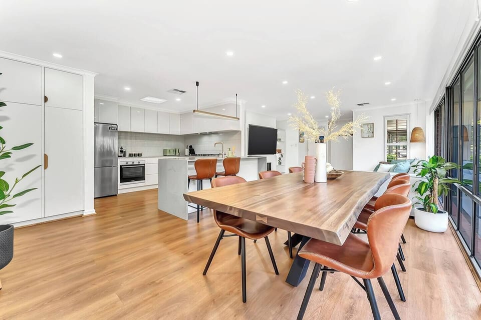 Gather around the feature timber dining table, surrounded by natural light and a chic, open-plan.