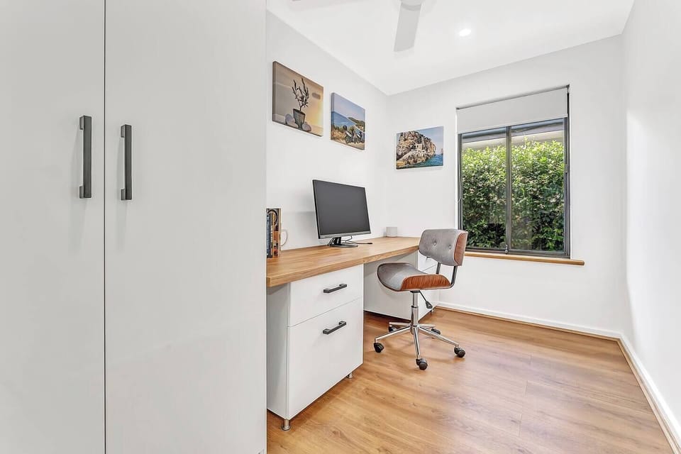A bright and inviting study space, complete with a modern desk and comfortable chair, perfect for remote work or quiet reading.