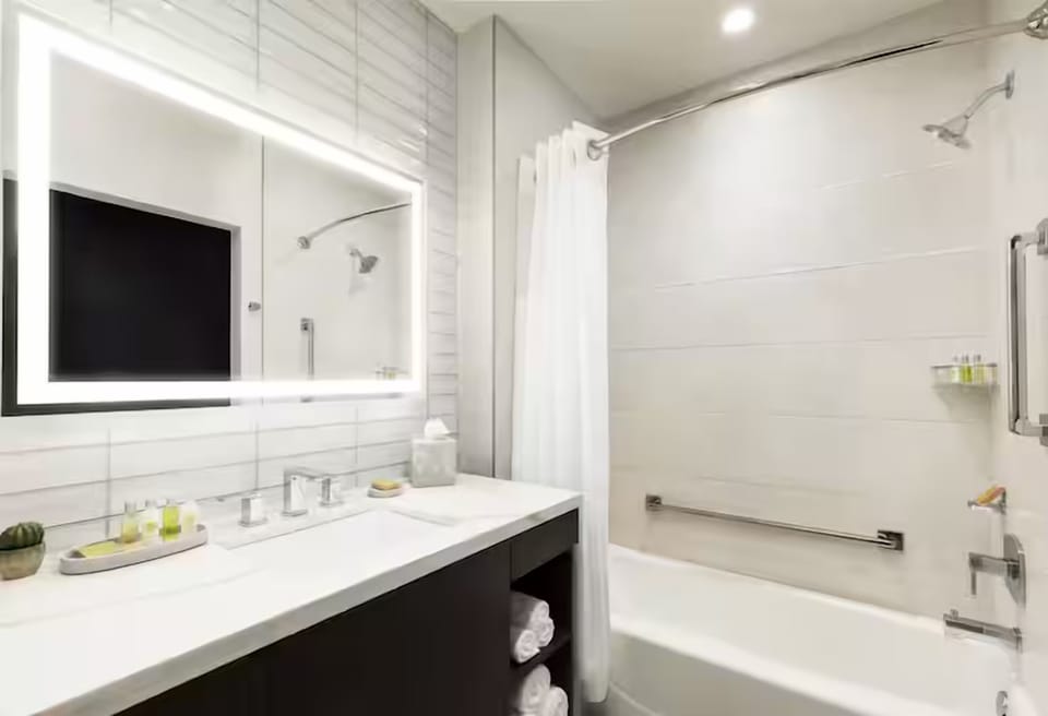 Soak and reset with a deep tub and glowing mirror light.