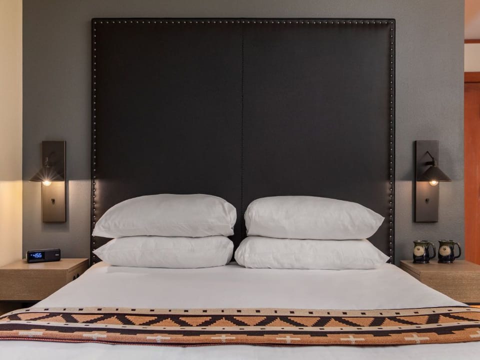 A cozy, inviting space featuring a plush bed and soft lighting, creating the perfect spot for relaxation and unwinding.