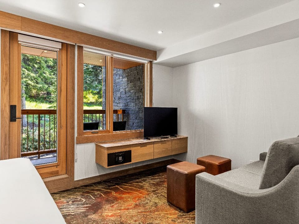 A cozy living area with a TV and large windows, offering a relaxing space to unwind and take in the natural surroundings.