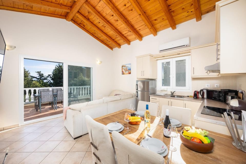 Open-plan living room with sofa, dining area, kitchen, A/C, WiFi internet, and satellite TV