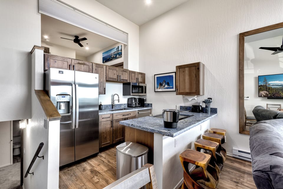 Fully equipped kitchen with stainless steel appliances and a breakfast bar.