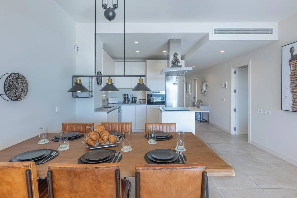 Spacious living room with L-shaped sofa, dining for 6, and terrace access with sea views. (7)