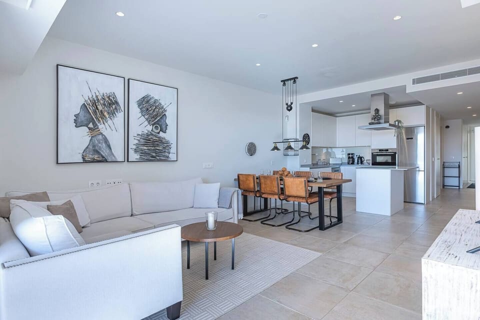 Spacious living room with L-shaped sofa, dining for 6, and terrace access with sea views. (2)
