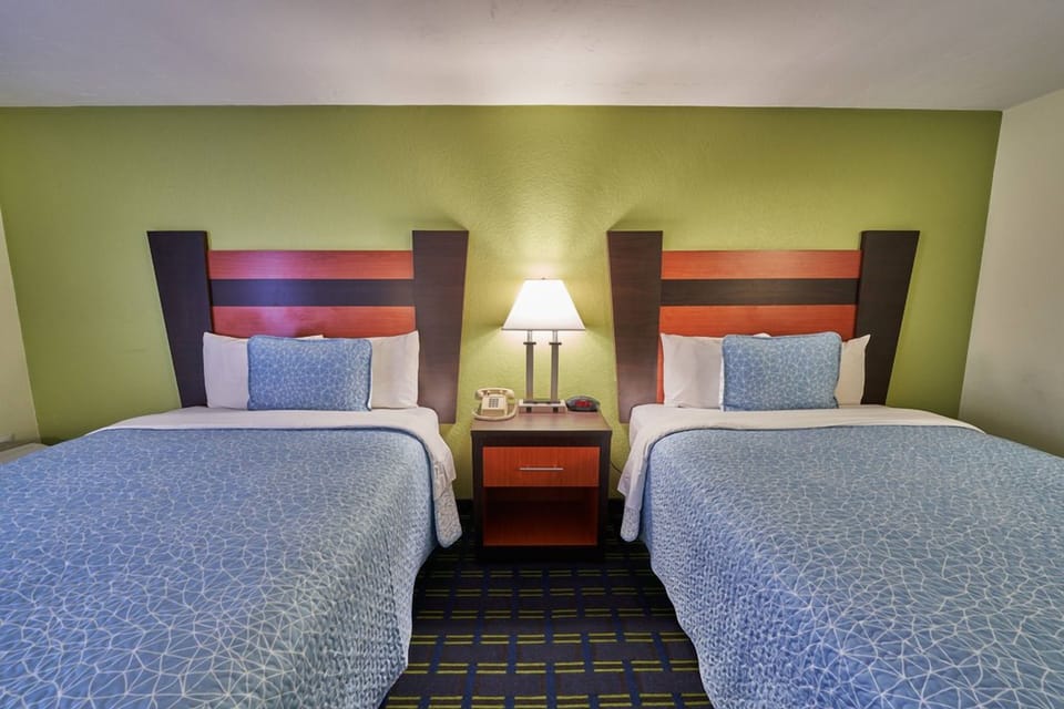 Unwind in crisp beds with warm lamps and calm tones.