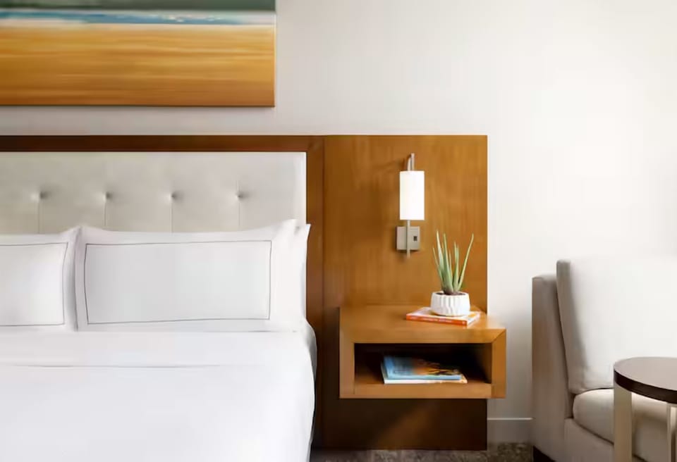 Sink into crisp linens beside warm lighting and bedside comforts.