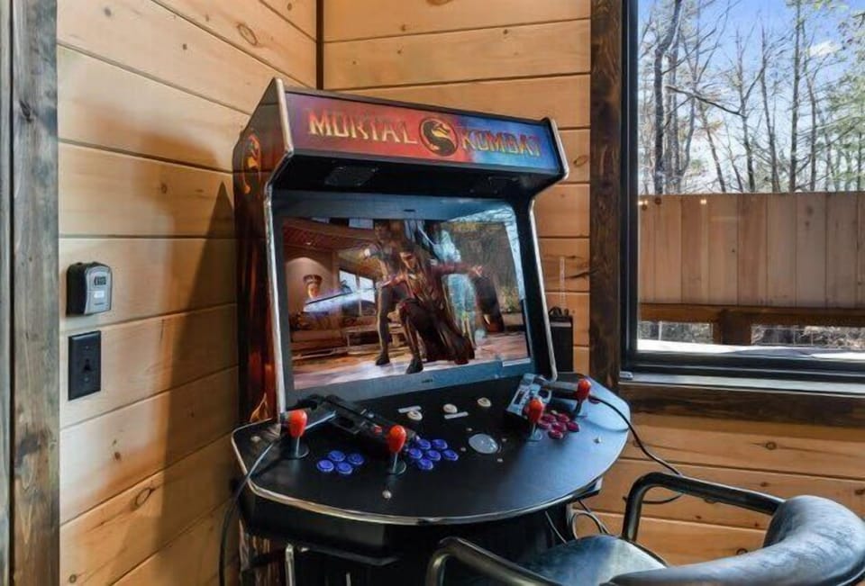 Classic mortal kombat arcade game setup in a cozy wood-paneled room with natural light.