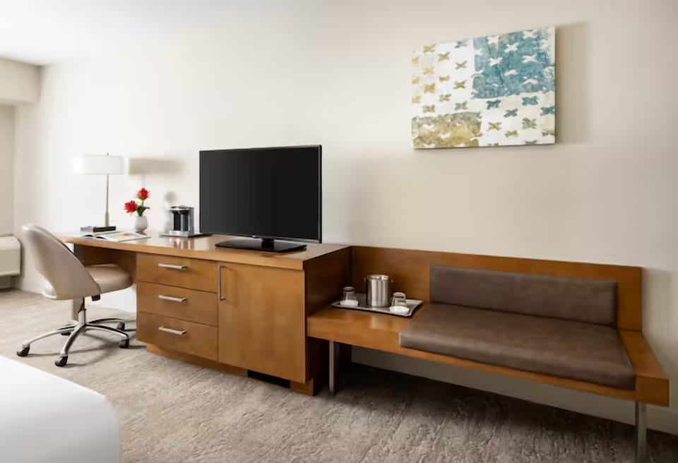 Unwind in a bright room with desk, TV, and sofa.
