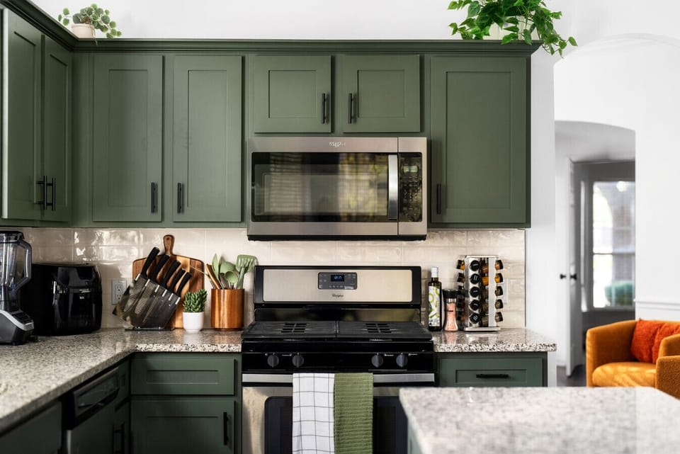 Cook and gather in this beautifully designed kitchen, featuring modern appliances, stylish green cabinetry, and a warm, inviting atmosphere!