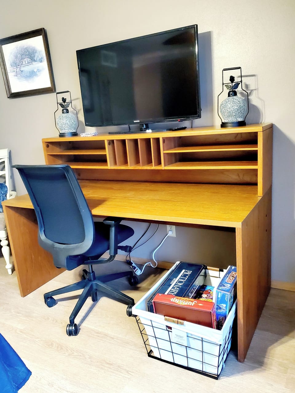 The dining room includes a desk for remote work. There is a smart TV on top.